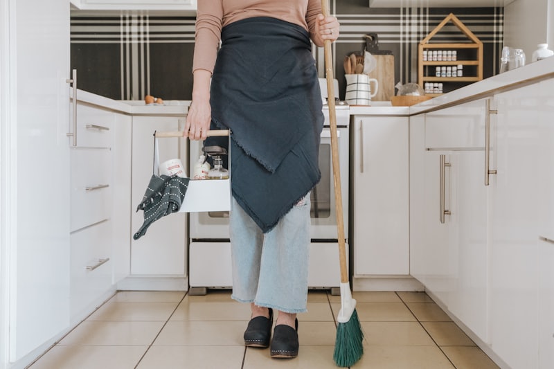 Cleaner tidying a bright kitchen