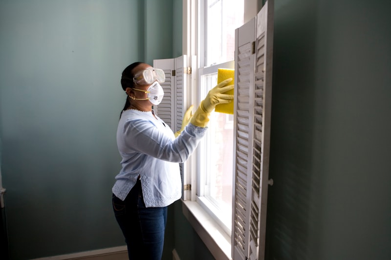 Person cleaning a large glass window